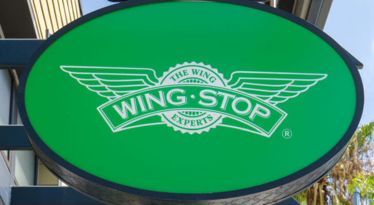 A close-up of a Wingstop (WING) sign on a green circle background.