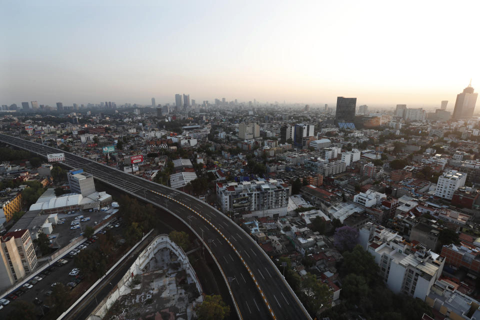 An elevated highway nearly devoid of traffic cuts into Mexico City, Sunday, March 22, 2020. Many countries in Latin America have taken aggressive measures to deal with the new coronavirus such as closing their borders, dock and airports to foreigners. Mexico, by contrast, has so far taken a "business as usual" attitude. The vast majority of people recover from the COVID-19 disease. (AP Photo/Marco Ugarte)