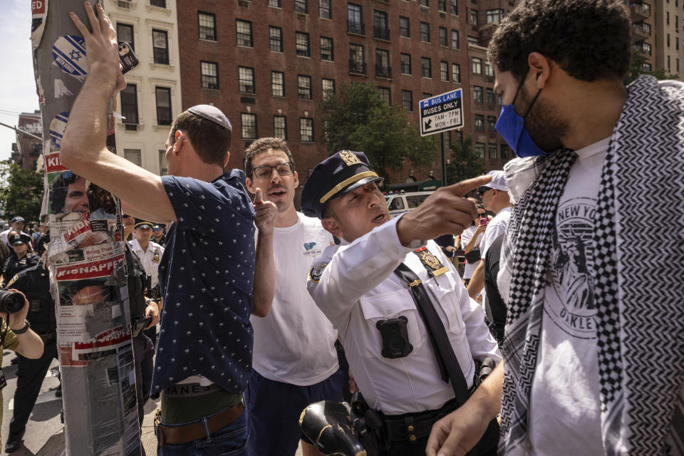 A New York City Police Department officer stops and argument between a pro-Palestinian protester and pro-Israel protester after the annual Israel Day Parade on Fifth Avenue on Sunday, June 2, 2024, in New York. (AP Photo/Yuki Iwamura)
