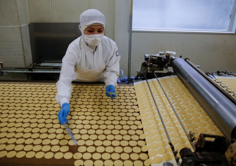 An employee inspects cookies at Izumiya Tokyoten's factory in Kawasaki