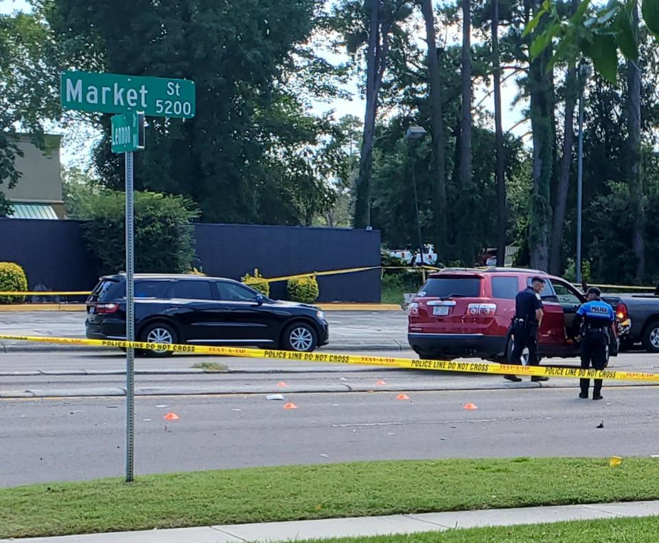 Authorities mark spots on Market Street near the intersection with Lennon Drive where a suspect was killed in a shootout with Wilmington police officers and New Hanover County Sheriff's deputies on Friday.