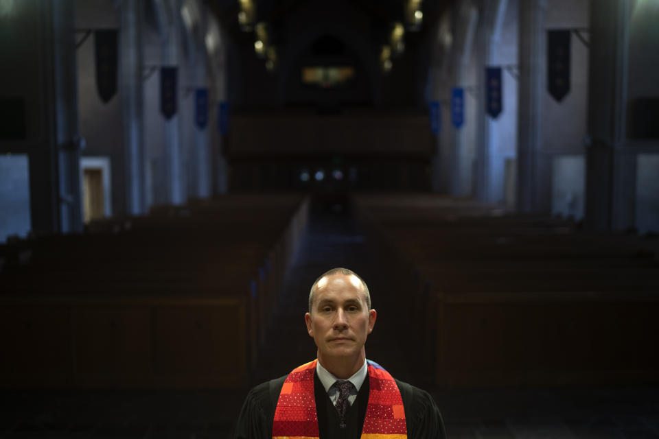 Rev. Stephen Cady stands for a portrait in the sanctuary of Asbury First United Methodist Church, Monday, Aug. 21, 2023, in Rochester, N.Y. On Sundays, the 44-year-old Cady applies Christian teachings to problems on the minds of a modern congregation. That has included repeated calls for an end to what he views as Americans’ warped worship of guns. “As a people of faith our adherence is not to the Second Amendment. It’s to the Second Commandment, which is ’Love your neighbor as yourself,” he says. “And more guns do not help you love your neighbor.” (AP Photo/David Goldman)