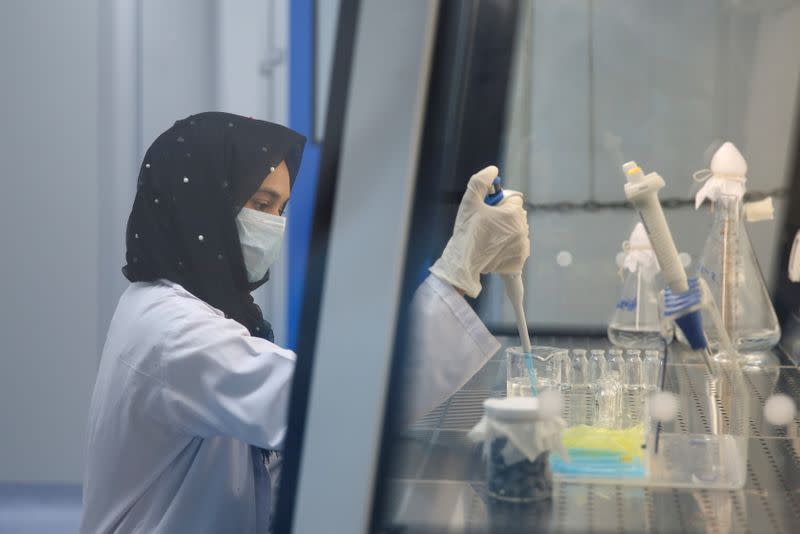 Ayesha Shehzadi, a lab technician, carries out testing procedure for the PakVac coronavirus disease (COVID-19) vaccine, which is being produced locally, at the National Institute of Health (NIH) in Islamabad