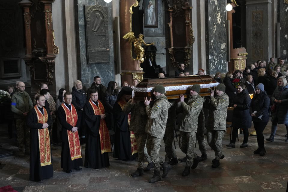 Ukrainian soldiers carry the coffin of one of the Ukrainian military servicemen, who were killed during an airstrike on a military base in Yarokiv, during a funeral ceremony in Lviv, Ukraine, Tuesday, March 15, 2022. At least 35 people were killed and many wounded in Sunday's Russian missile strike on a military training base near Ukraine's western border with NATO member Poland. (AP Photo/Bernat Armangue)
