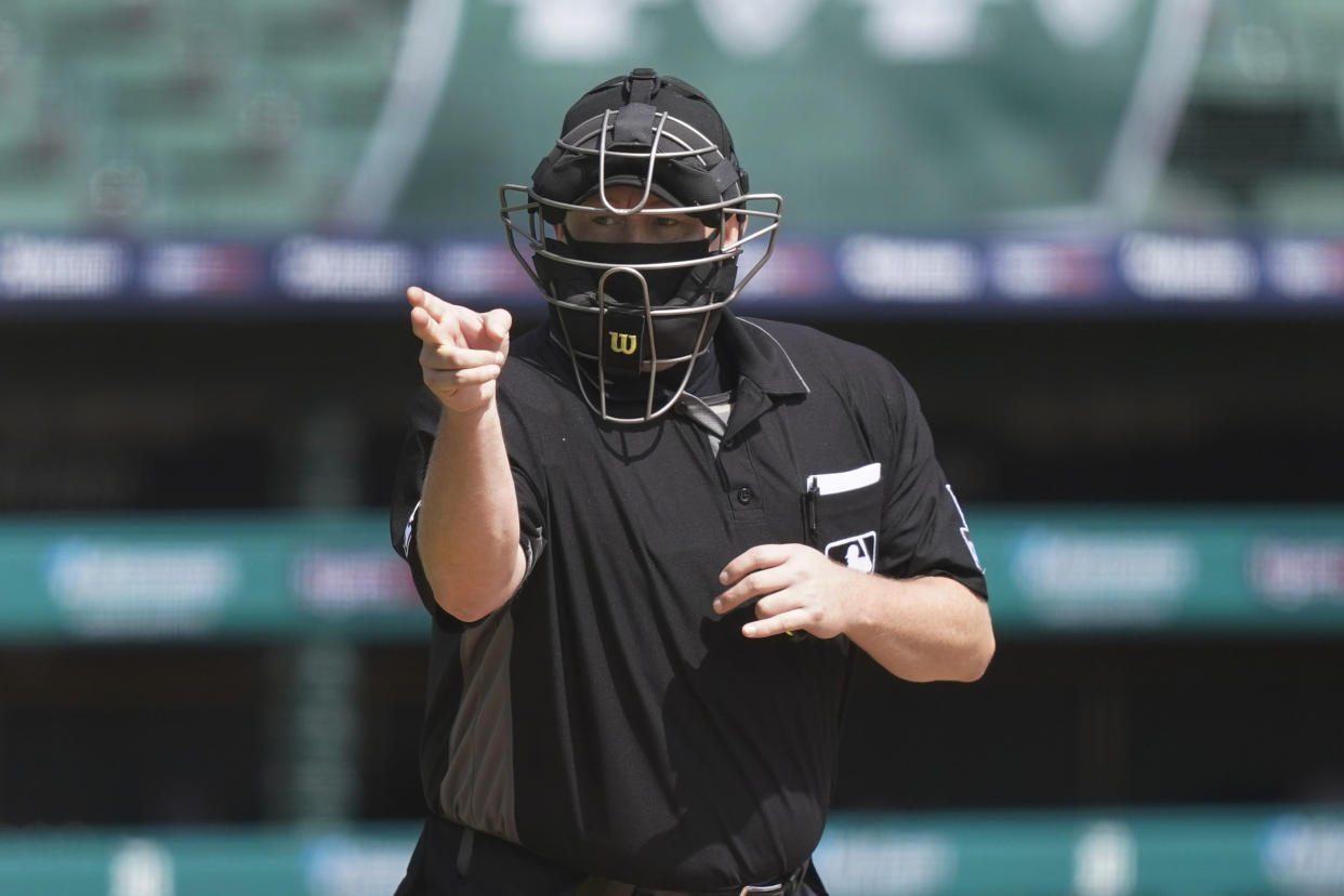 Home plate umpire Todd Tichenor signals during the fourth inning of the first baseball game of a doubleheader between the Detroit Tigers and the Minnesota Twins, Saturday, Aug. 29, 2020, in Detroit. (AP Photo/Carlos Osorio)