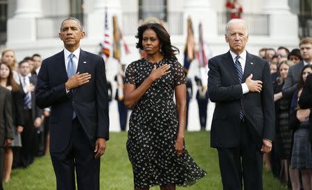 (L to R) U.S. President Barack Obama, U.S. first lady Michelle Obama and Vice President Joe Biden observe a moment of silence on the 13th anniversary of the 9/11 attacks at the White House in Washington September 11, 2014. REUTERS/Kevin Lamarque