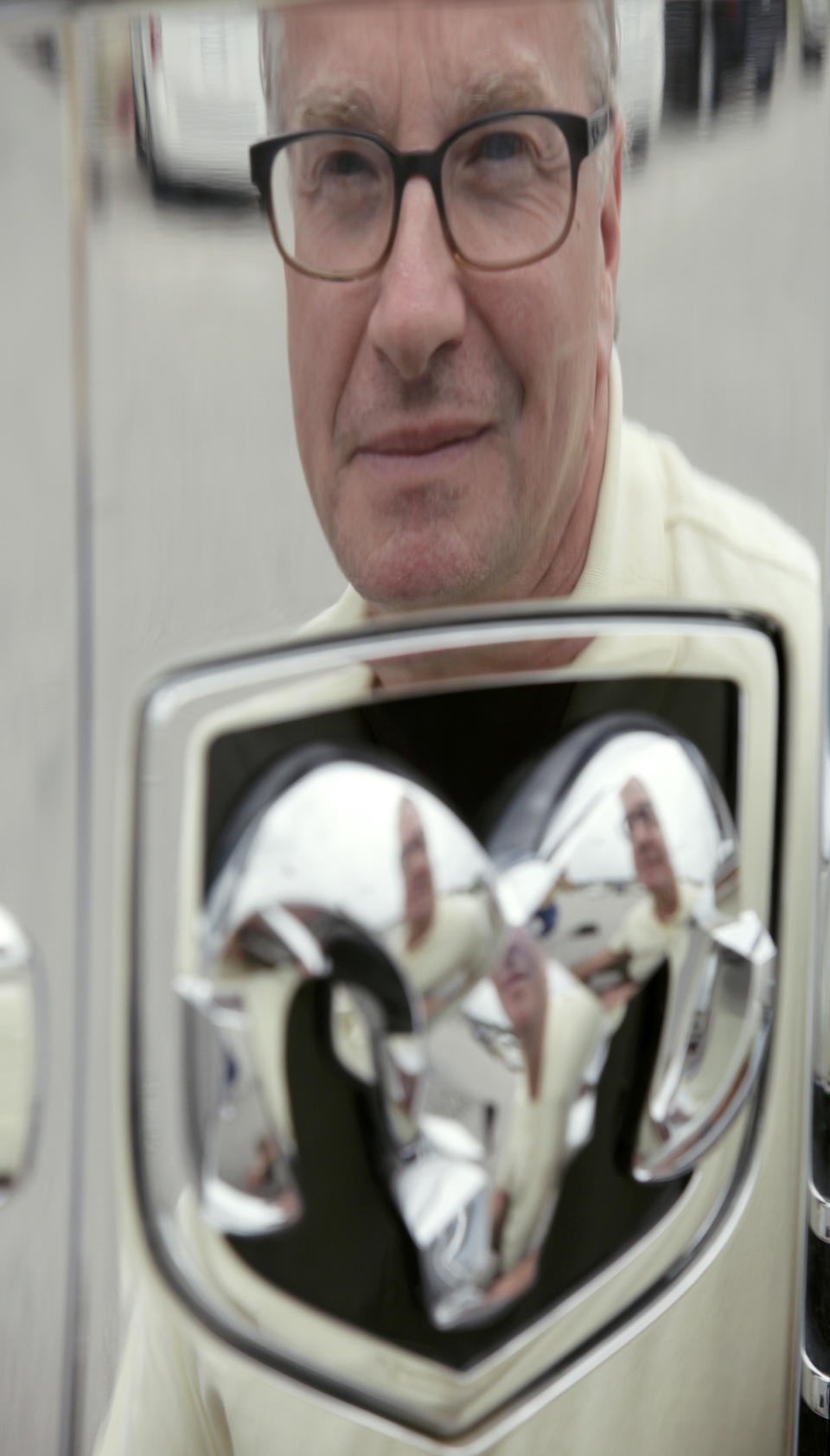 This Wednesday, June 20, 2012 photo shows Mark Beardmore reflected in the front of a pickup truck at the auto dealership where he works in Carroll, Iowa. "Government needs to stay out of more things rather than infuse itself in more things," says Beardmore, a county commissioner whose stance might seem unlikely since he’s a Chrysler salesman. Though the automaker was on the brink of collapse before a government rescue, he's convinced it would have survived, maybe with an investment from China or another foreign country. Beardmore also thinks the move won the president political points. "I think Mr. Obama went to bed saying I've got to do something to save these jobs," he says. "I don't think he was laying his head on the pillow saying I've got to appease the unions. I think that was a side benefit." (AP Photo/Charlie Neibergall)