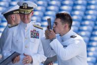 <p>An U.S. Naval Academy graduate kisses his diploma during a ceremony in Annapolis, Md., on May 25, 2018. (Photo: Jim Watson/AFP/Getty Images) </p>