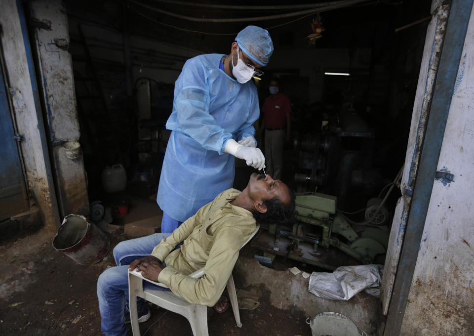 A health worker takes a nasal swab sample to test for COVID-19 in Ahmedabad, India, Sunday, Sept. 6, 2020. India's coronavirus cases have crossed 4 million, leading the world in new infections and deepening misery in the country's vast hinterlands where surges have crippled the underfunded health care system (AP Photo/Ajit Solanki)