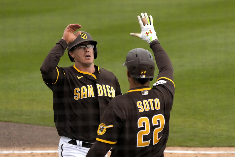 San Diego Padres' Brandon Dixon, left, celebrates with Juan Soto (22) after scoring on a double by Tim Lopes during the fourth inning of a spring training baseball game against the Texas Rangers Wednesday, March 1, 2023, in Peoria, Ariz. (AP Photo/Charlie Riedel)