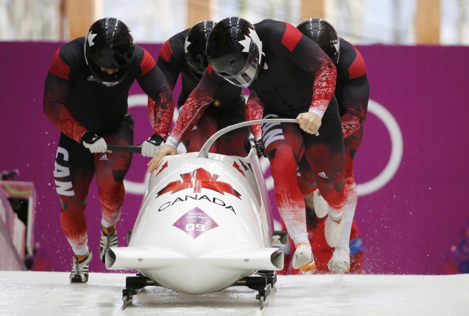 Canada's pilot Rush and his teammates start during a heat of the four-man bobsleigh event at the Sochi 2014 Winter Olympics