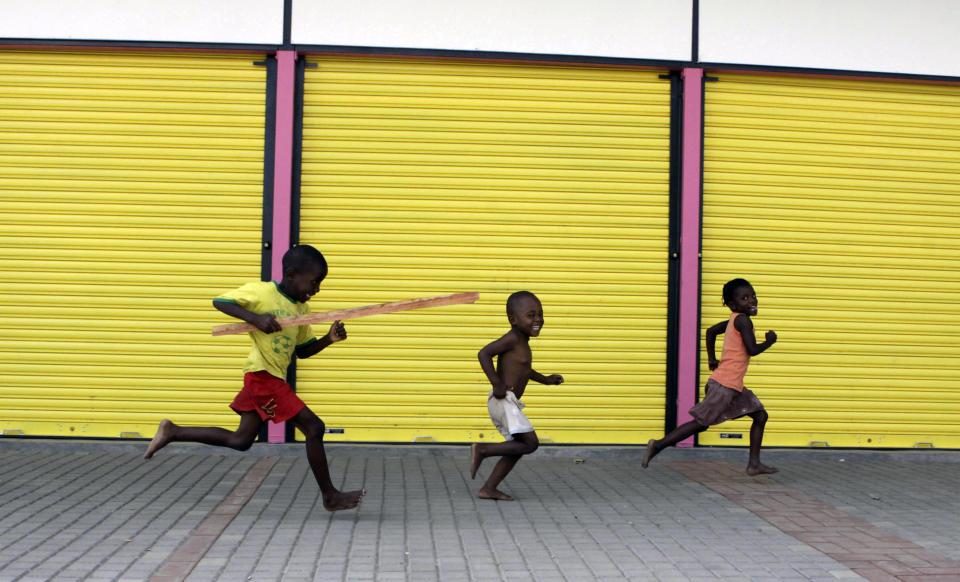 In this March 6, 2012 photo, children run through a taxi rank in the Zandspruit township, north of Johannesburg. Not so long ago banks wouldn't have been concerned about providing services for poor people who want their children educated well. Now banks accross Africa are seeing opportunity in the slums. (AP Photo/Denis Farrell)