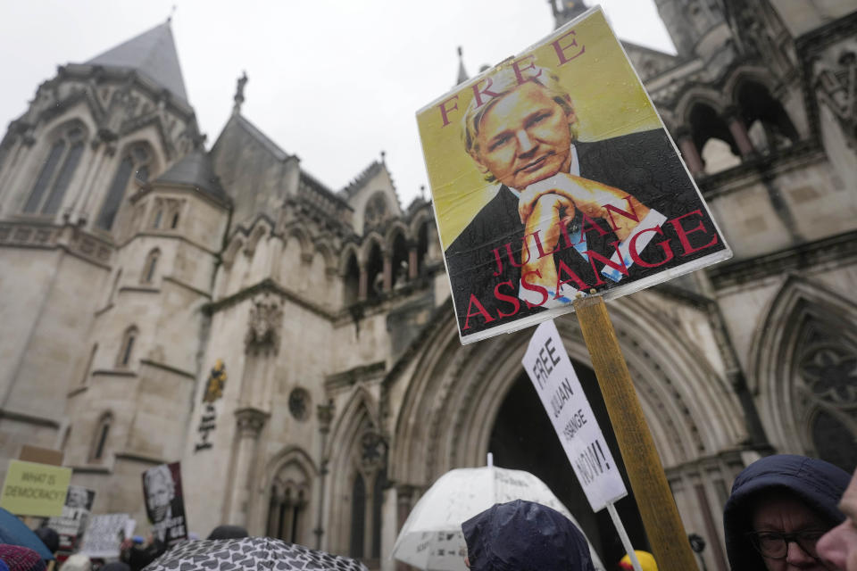 Protesters stand with posters at the Royal Courts of Justice entrance in London, Wednesday, Feb. 21, 2024. Julian Assange's lawyers are on their final U.K. legal challenge to stop the WikiLeaks founder from being sent to the United States to face spying charges. The 52-year-old has been fighting extradition for more than a decade, including seven years in self-exile in the Ecuadorian Embassy in London and the last five years in a high-security prison. (AP Photo/Alastair Grant)