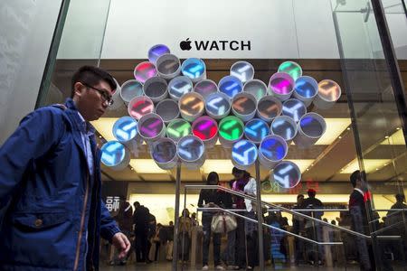 A man walks past a window display for Apple Watch outside an Apple Store in Hong Kong April 10, 2015. REUTERS/Tyrone Siu