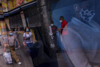 Pedestrians wear face masks to prevent the spread of coronavirus in the southern neighborhood of Vallecas in Madrid, Spain, Wednesday, Sept. 16, 2020. The Spanish capital will introduce selective lockdowns in urban areas where the coronavirus is spreading faster, regional health authorities announced on Tuesday. The measures in Madrid will most likely affect southern, working-class neighborhoods where virus contagion rates have been steadily soaring since August. (AP Photo/Bernat Armangue)