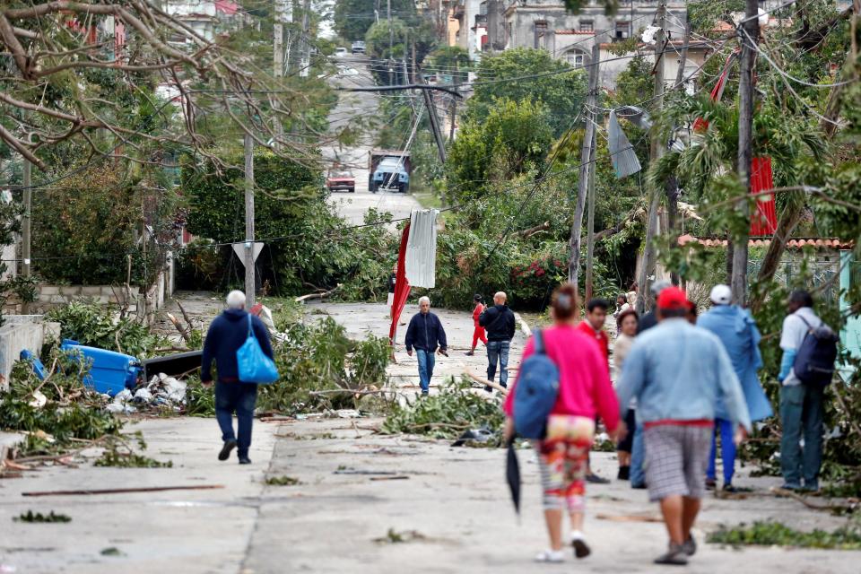 AME4766. LA HABANA (CUBA), 28/01/2019.- Vecinos caminan por una calle afectada por el paso de un tornado, este lunes, en La Habana (Cuba). Al menos tres personas han muerto y 172 han resultado heridas por un tornado que azotó esta madrugada la barriada de Regla, en La Habana, informó hoy el presidente de Cuba, Miguel Díaz-Canel. EFE/Ernesto Mastrascusa