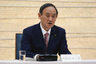 Japanese Prime Minister Yoshihide Suga announces that Tokyo, Kyoto and Okinawa will be applied for pre-emergency status under a new prevention law during a government task force meeting at the prime minister's office Friday, April 9, 2021, in Tokyo. Japan announced Friday that it will raise the coronavirus alert level in Tokyo to allow tougher measures to curb the rapid spread of a more contagious variant ahead of the Summer Olympics. (AP Photo/Eugene Hoshiko, Pool)