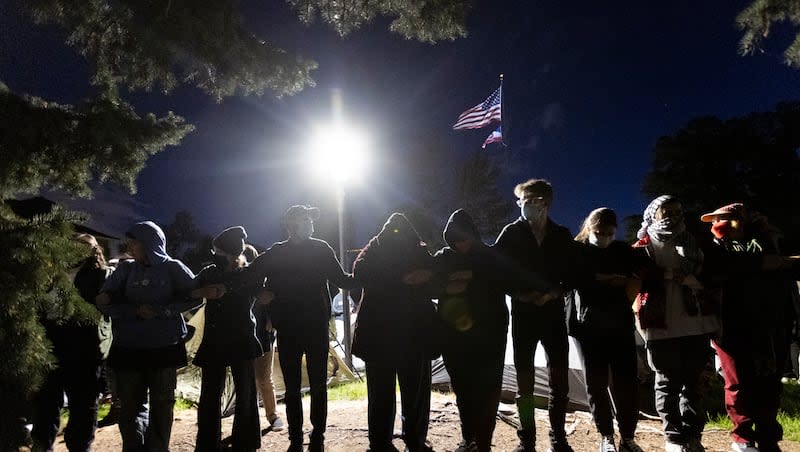 Demonstrators lock arms and surround an encampment in support of Palestine at the University of Utah in Salt Lake City on Monday, April 29, 2024.