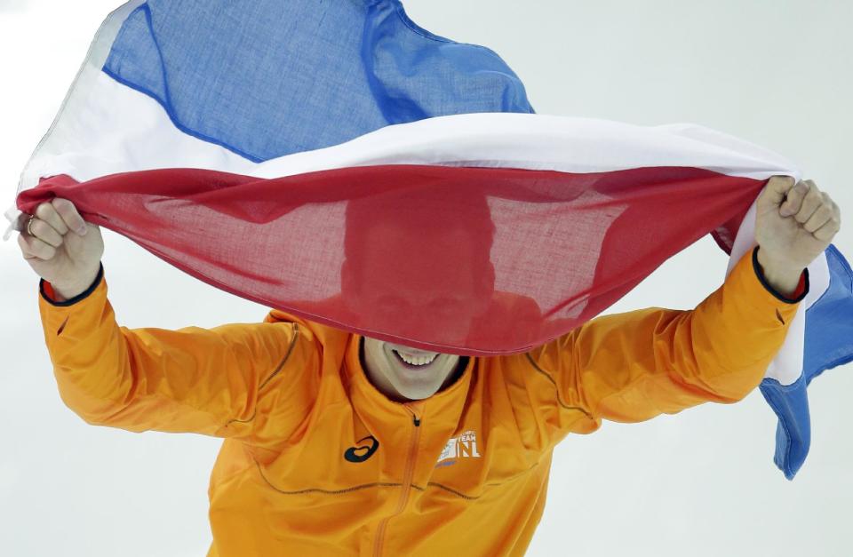 Stefan Groothuis of the Netherlands holds his national flag and celebrates after winning the gold in the men's 1,000-meter speedskating race at the Adler Arena Skating Center at the 2014 Winter Olympics in Sochi, Russia, Wednesday, Feb. 12, 2014. (AP Photo/Patrick Semansky)