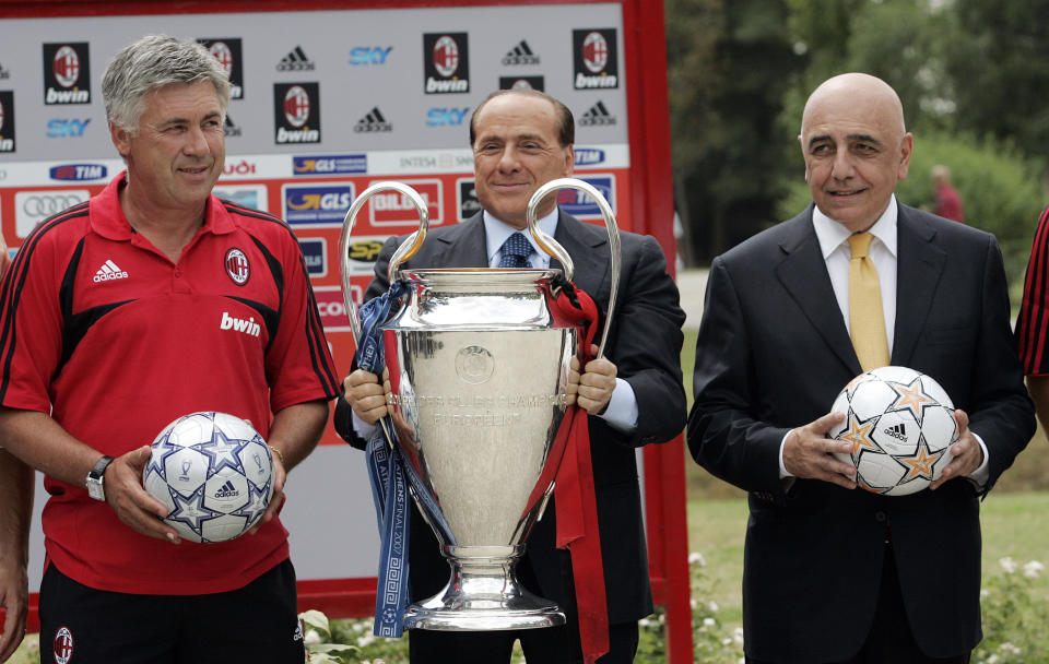 FILE - From left, AC Milan's coach Carlo Ancelotti , President Silvio Berlusconi and vice-president Adriano Galliani pose with the Champions League trophy at the Milanello training facility, in Carnago, Italy, on July 23, 2007. Berlusconi, the boastful billionaire media mogul who was Italy's longest-serving premier despite scandals over his sex-fueled parties and allegations of corruption, died, according to Italian media. He was 86. (AP Photo/Luca Bruno, File)