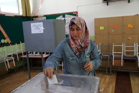 A Turkish Cypriot woman cast her vote at a polling station in northern Nicosia, Sunday April 26, 2015. REUTERS/Yiannis Kourtoglou