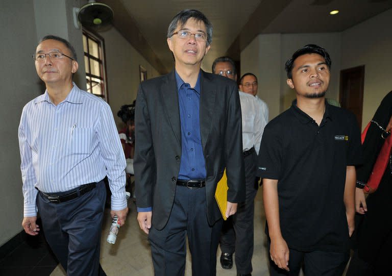 PKR vice-president Tian Chua (C) and student activist Safwan Anang (R) arrive at the High Court in Kuala Lumpur on May 29, 2013. A Malaysian court on Wednesday charged four people with sedition as part of what critics have decried as a crackdown on accusations that the government cheated to win recent elections