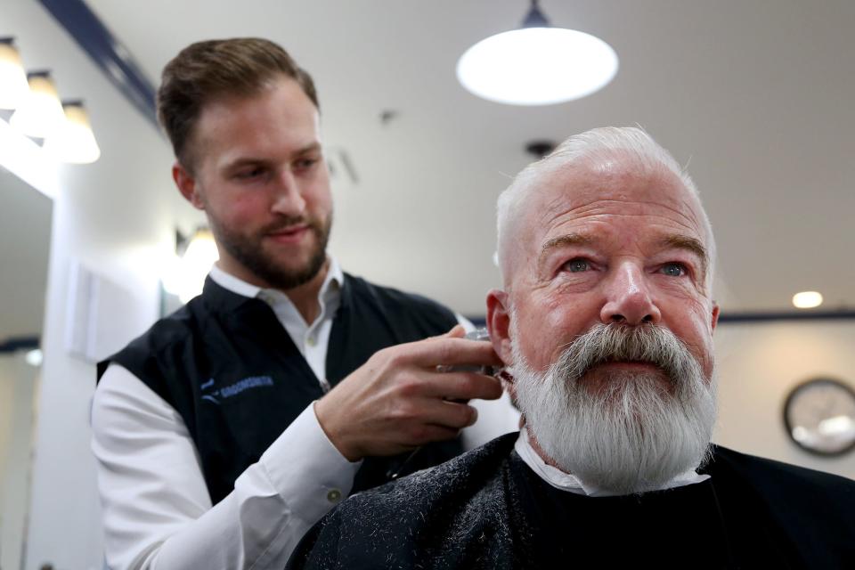 Reed Maerder, owner of the Groomsmith in Portsmouth, gives Bill MacDonald his bi-weekly haircut and beard trim on Tuesday, March 15, 2022.