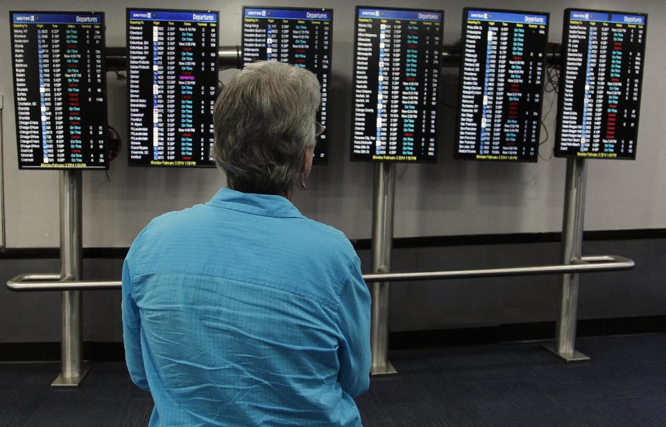 United passenger Jan Cloos, of Detroit, Mich. looks at her flights status at Newark Liberty International Airport, Monday, Feb. 3, 2014, in Newark, N.J. Many flights were cancelled at the airport due to snow fall. (AP Photo/Mike Stewart)