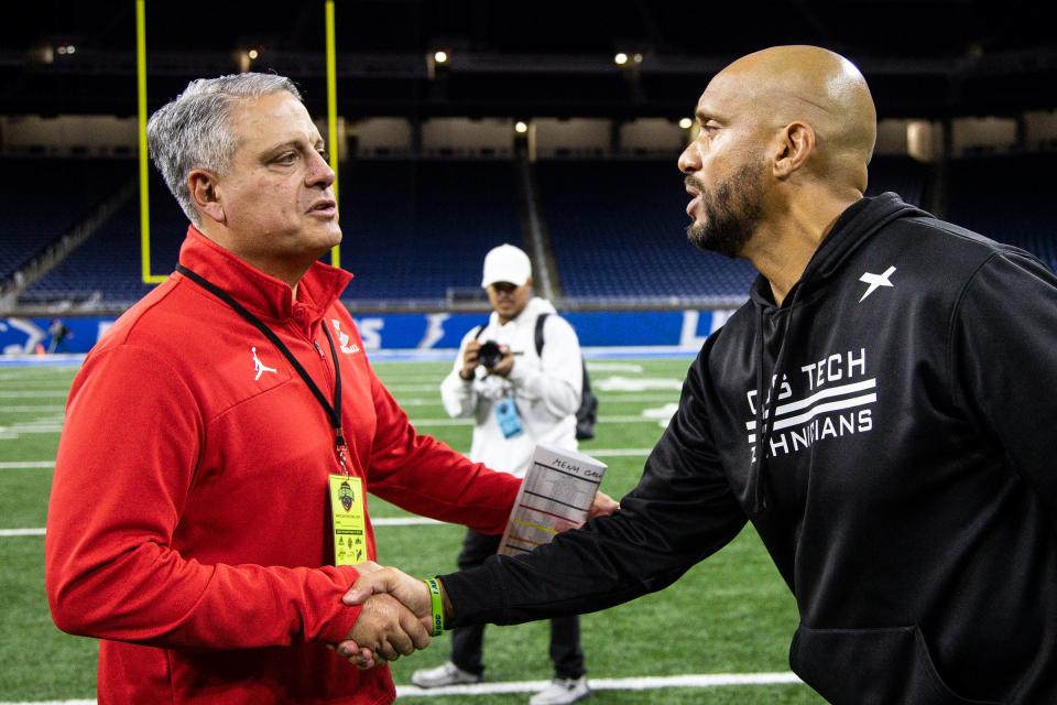 Detroit Cass Tech head coach Marvin Rushing, right, shakes hand with Toledo Central Catholic head coach Greg Dempsey after the Technicians lost 48-23 at Ford Field in Detroit on Saturday, Oct. 21, 2023.