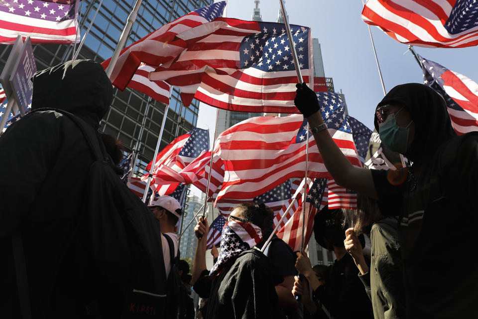 Protesters march to U.S. Consulate during a rally in Hong Kong, Sunday, Dec. 1, 2019. Hong Kong protesters carrying American flags and banners appealing to President Donald Trump are rallying in the semi-autonomous Chinese territory. (AP Photo/Vincent Thian)