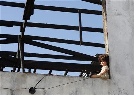 A doll is seen at a window of a roofless house damaged by Typhoon Haiyan in Tanauan, Leyte, central Philippines November 14, 2013. REUTERS/Erik De Castro