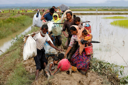 Children fall down as a group of Rohingya refugee people walk on the muddy path after crossing the Bangladesh-Myanmar border in Teknaf, Bnagladesh, September 1, 2017. REUTERS/Mohammad Ponir Hossain