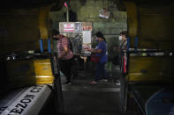 Passengers prepare to show their vaccination card before riding a passenger jeep at a terminal in Quezon city, Philippines on Monday, Jan. 17, 2022. People who are not fully vaccinated against COVID-19 were banned from riding public transport in the Philippine capital region Monday in a desperate move that has sparked protests from labor and human rights groups. (AP Photo/Aaron Favila)