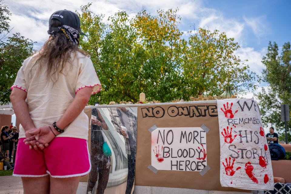 A demonstrator stands paying homage at a mural in protest against the reinstallation of a 16th-century New Mexico conquistador (Getty Images)