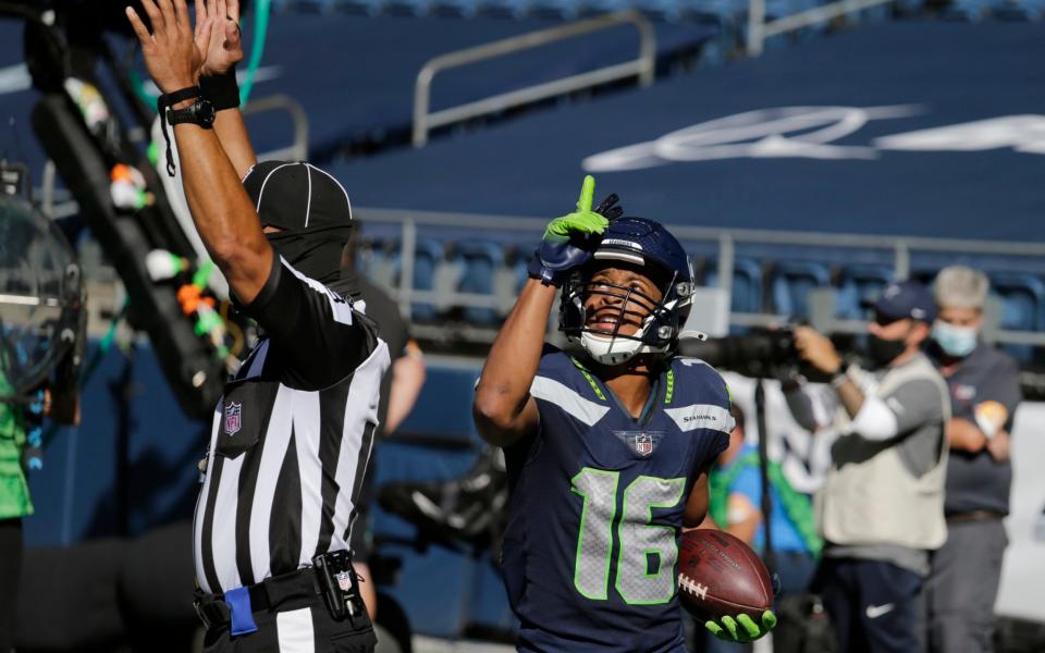 Seattle Seahawks wide receiver Tyler Lockett holds the ball and reacts after scoring a touchdown against the Dallas Cowboys during the first half of an NFL football game, Sunday, Sept. 27, 2020, in Seattle. - AP