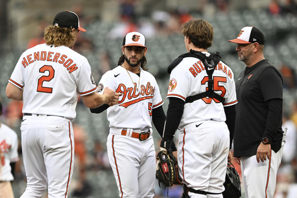 Baltimore Orioles pitcher Clonel Perez, center, is congratulated by Gunnar Henderson after recovering from being hit by a line drive in the leg to throw out Houston Astros Kyle Tucker in the eighth inning of a baseball game, Sunday, Sept. 25, 2022, in Baltimore. Also pictured is manager Brandon Hyde and catcher Adley Rutschman. The Astros won 6-3 in 11 innings. (AP Photo/Gail Burton)