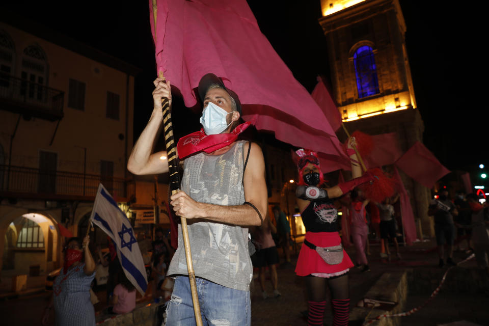 People chant slogans during a protest against Prime Minister Benjamin Netanyahu in Jaffa, Israel, Thursday, Oct. 8, 2020 during a nationwide lockdown to curb the spread of the coronavirus. The Israeli government has extended an emergency provision that bars public gatherings, including widespread protests against Netanyahu, for an additional week. (AP Photo/Ariel Schalit)