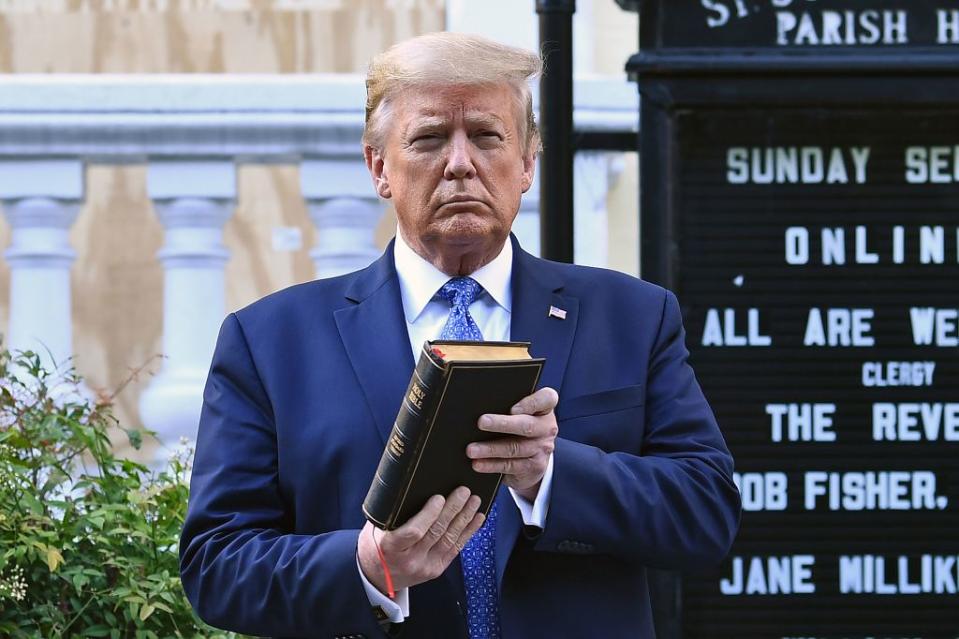 Pictured is US President Donald Trump posing for a photograph as he holds a bible outside the St John's Church, which was set alight amid George Floyd protests. 