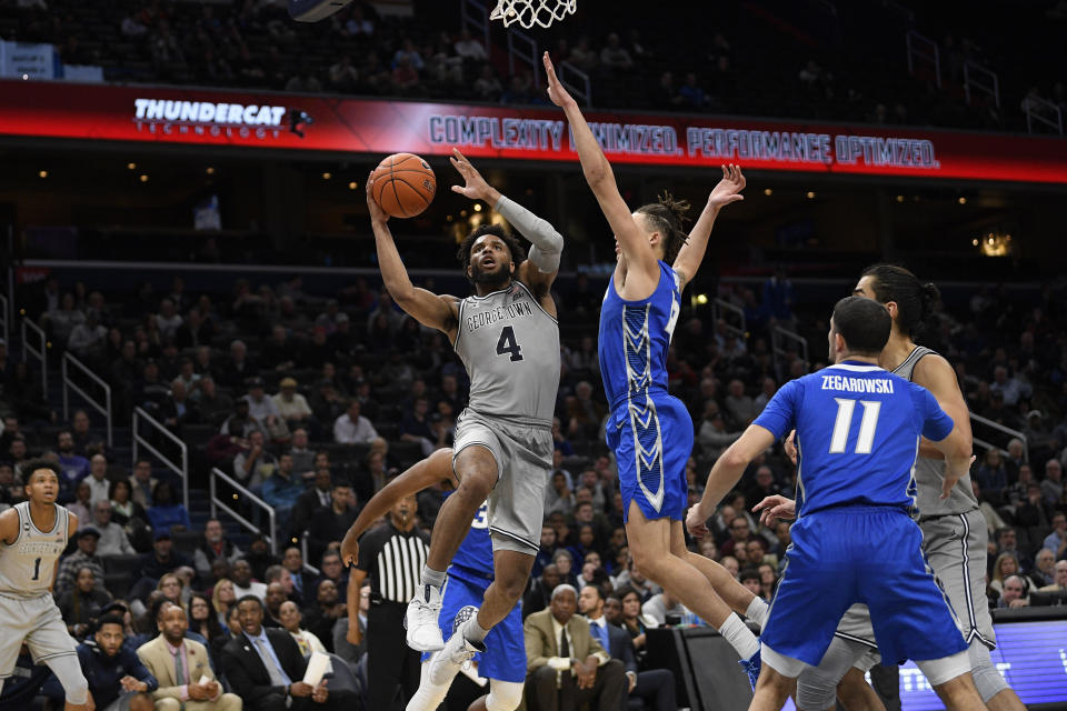 Georgetown guard Jagan Mosely (4) goes to the basket next to Creighton forward Christian Bishop, right center and guard Marcus Zegarowski (11) during the second half of an NCAA college basketball game, Wednesday, Jan. 15, 2020, in Washington. Georgetown won 83-80. (AP Photo/Nick Wass)