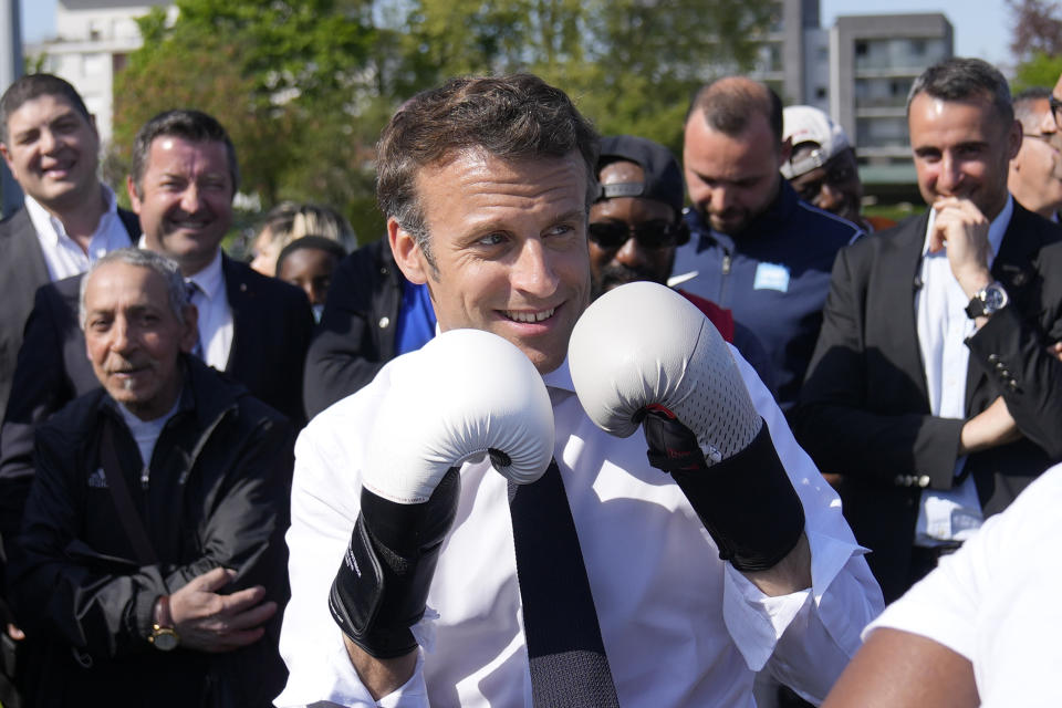 FILE - Centrist presidential candidate and French President Emmanuel Macron wears boxing gloves as he campaigns in the Auguste Delaune stadium Thursday, April 21, 2022 in Saint-Denis, outside Paris. French President Emmanuel Macron is raising eyebrows after photos of him hammering a punching bag were posted to his official photographer's social media. (AP Photo/Francois Mori, Pool, File)
