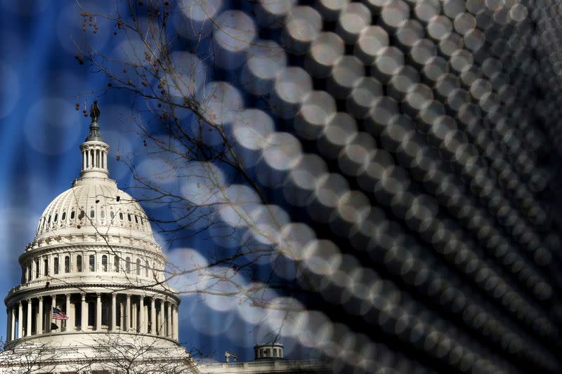 FILE PHOTO: Light catches the security fence around the U.S. Capitol, erected in the wake of the January 6th attack but now scheduled to start being removed, in Washington