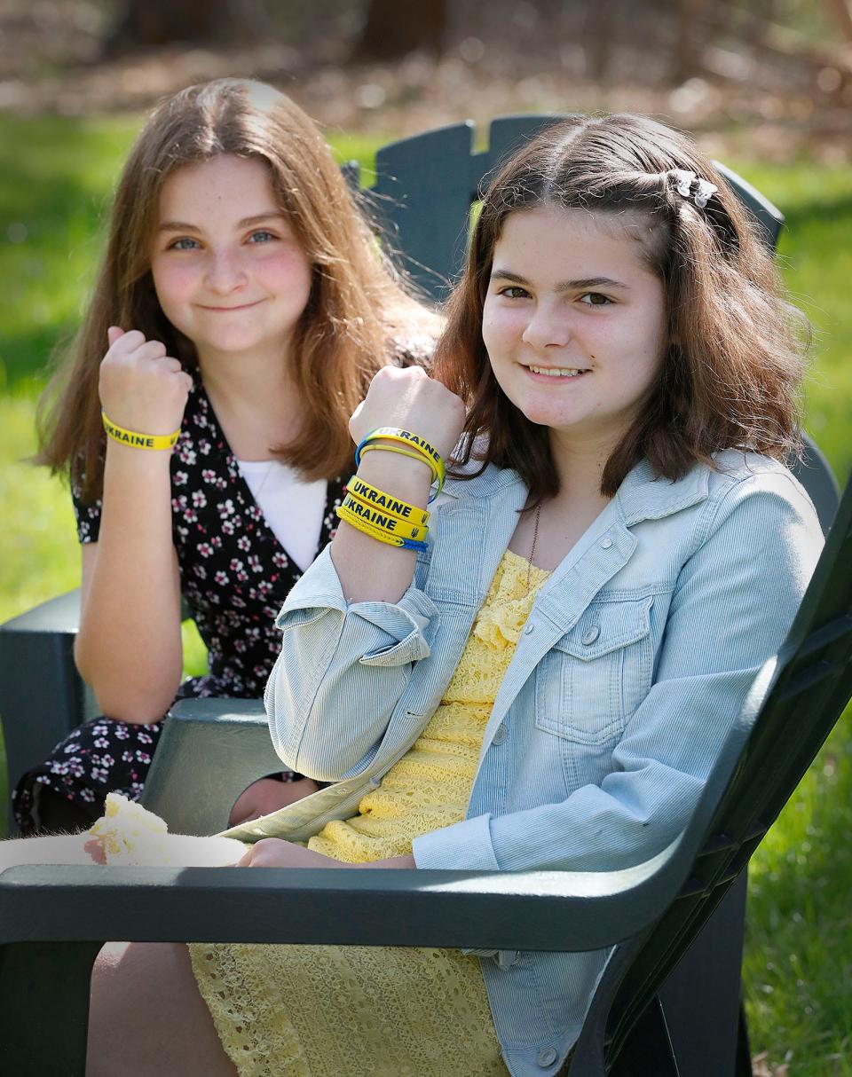 Pembroke fifth graders Madeline Rejewski and Violet Carson, both 11, with bracelets they plan to sell to benefit Ukraine on Thursday, May 5, 2022.