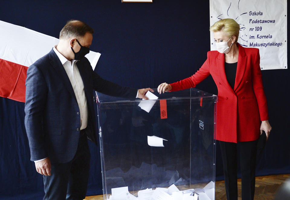 Candidate in Poland's tight presidential election runoff, incumbent President Andrzej Duda and First Lady Agata Kornhauser-Duda cast their ballots at a polling station in their hometown of Krakow, Poland, on Sunday, July 12, 2020. Conservative Duda is running against liberal Warsaw Mayor Rafal Trzaskowski and latest opinion polls suggest the race will be decided by a very narrow margin.(AP Photo/Czarek Sokolowski)