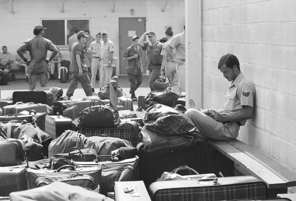In this March 27, 1973 photo, surrounded by luggage of other departing GIs, U.S. Air Force airman reads paperback novel as he waits to begin processing at Camp Alpha on Saigon's Tan Son Nhut airbase in Saigon as troop withdrawals resume after 10 day-delay.