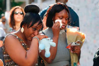 <p>Two women cry as they bring flowers, in the aftermath of the June 14 Grenfell Tower block fire, in Kensington, west London, on June 17, 2017. (Tolga Akmen/AFP/Getty Images) </p>