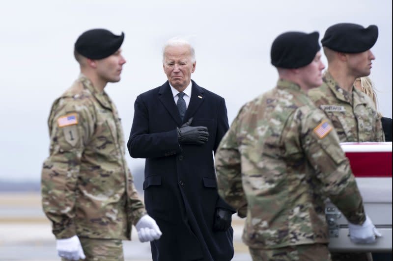 President Joe Biden watches as a U.S. Army carry team carries the transfer case containing the body of of Army Sgt. Kennedy Sanders during a dignified transfer at Dover Air Force Base in Dover, Del., on Friday.The United States launched airstrikes in Syria and Iraq Friday in retaliation for the killing of the U.S. soldiers last Sunday. Photo by Bonnie Cash/UPI