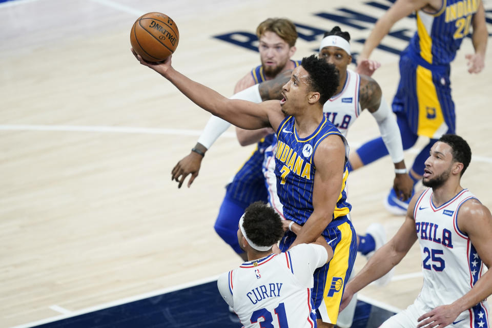 Indiana Pacers' Malcolm Brogdon (7) puts up a shot against Philadelphia 76ers' Seth Curry (31) during the first half of an NBA basketball game, Sunday, Jan. 31, 2021, in Indianapolis. (AP Photo/Darron Cummings)