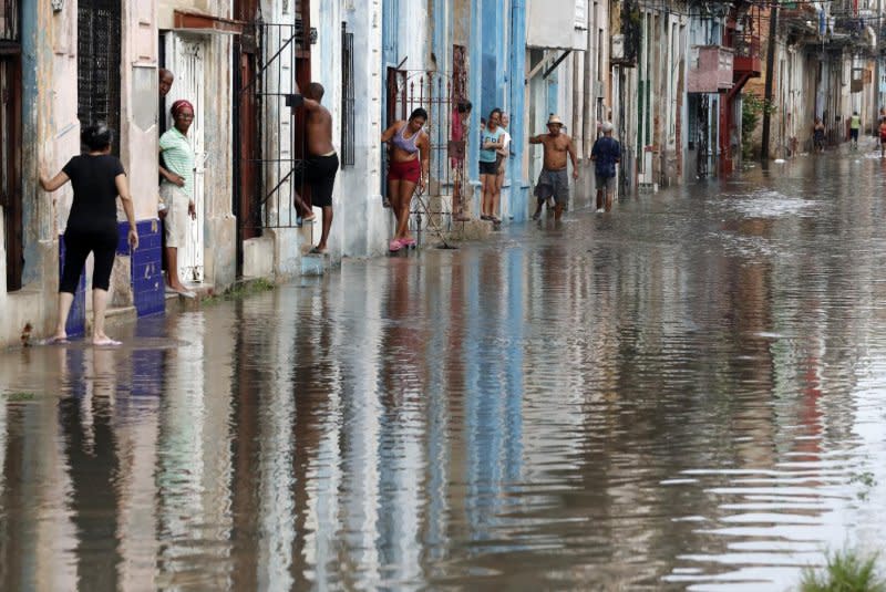 Residents lean out of their houses next to a flooded street in Havana, Cuba, on Tuesday, after Tropical Storm Idalia's heavy winds and rain caused widespread flooding and power outages in western Cuba. Idalia has strengthened to a hurricane and is expected to make landfall in Florida on Wednesday. Photo by Ernesto Mastracusa/EPA-EFE