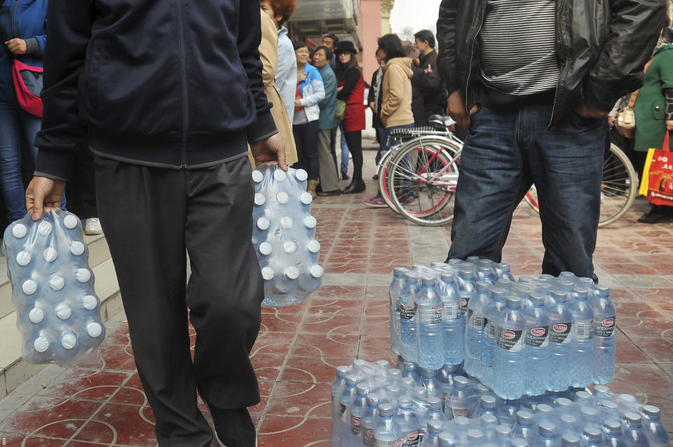 In this Friday, April 11, 2014 photo, people line up to buy bottled water in the northwestern city of Lanzhou, Gansu province, China. An oil pipe leak caused excessive levels of the toxic chemical benzene in a major Chinese city's water supply, prompting warnings against drinking from the tap and sending residents to queue up to buy bottled water. (AP Photo) CHINA OUT