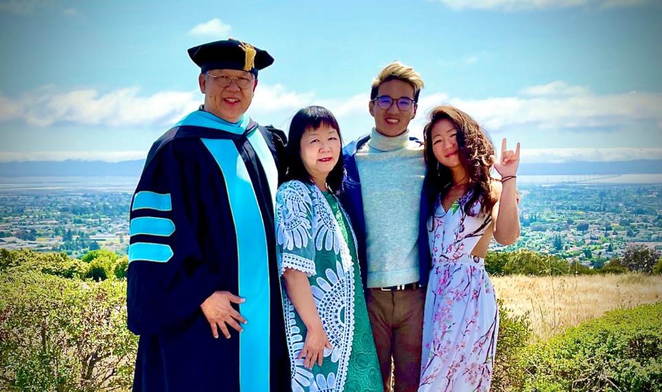 Gabriella Wong (signing "I love you" in American Sign Language) with her parents, William and Amelia, and brother Jeremy in 2021, at her father's education doctoral graduation from California State University, East Bay.